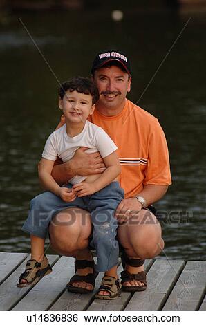 Father with his son on his knee View Large Photo Image Stock Photograph - Father with his son on his knee. Fotosearch