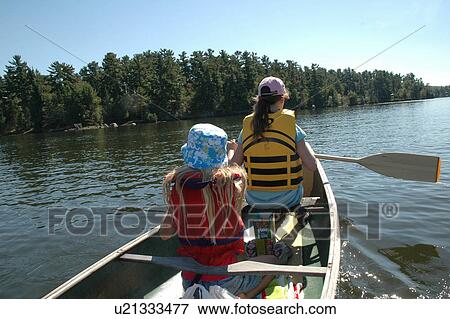 Stock Photo - Girls in Front of Canoe. Fotosearch