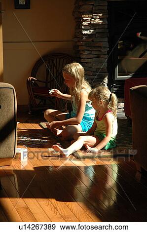 Girls sitting on the floor doing a puzzle View Large Photo Image Stock Photo - Girls sitting on the floor doing a puzzle. Fotosearch