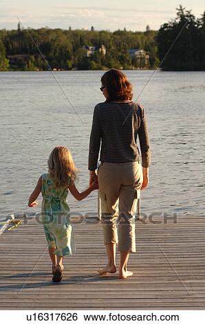 Mother and daughter on dock overlooking lake View Large Photo Image Stock Photograph - Mother and daughter on dock overlooking lake. Fotosearch