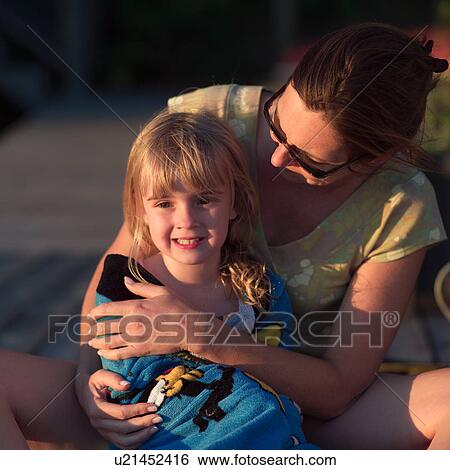 Stock Photograph - Mother cuddling young girl. Fotosearch