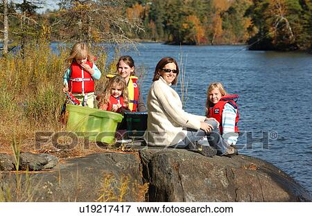 Mother with Children sitting on Rock at Water's Edge View Large Photo Image Stock Photo - Mother with Children sitting on Rock at Water's Edge. Fotosearch