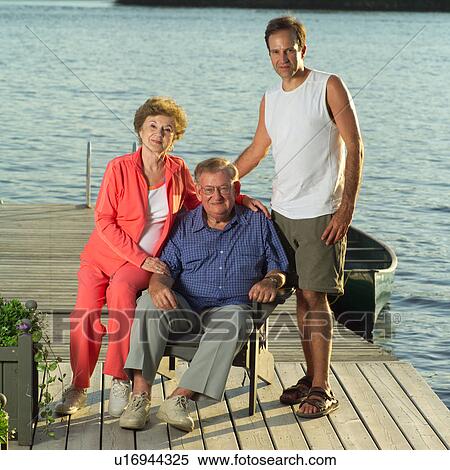 Parents posing with their adult son View Large Photo Image Stock Photography - Parents posing with their adult son. Fotosearch