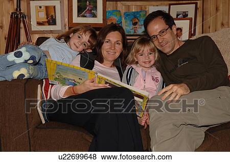 Parents reading a book to their children View Large Photo Image Stock Photo - Parents reading a book to their children. Fotosearch