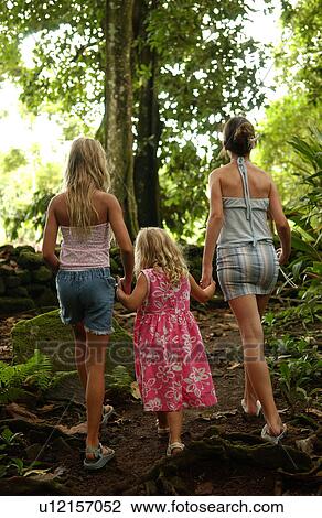 Rear view of two young women with a young girl (6-8) in a forest View Large Photo Image Stock Image - Rear view of two young women with a young girl (6-8) in a forest. Fotosearch