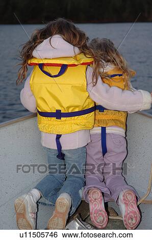Two girls kneeling at edge of boat View Large Photo Image Stock Photograph - Two girls kneeling at edge of boat. Fotosearch