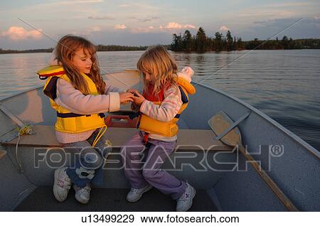 Two girls sitting in a boat View Large Photo Image Stock Photo - Two girls sitting in a boat. Fotosearch
