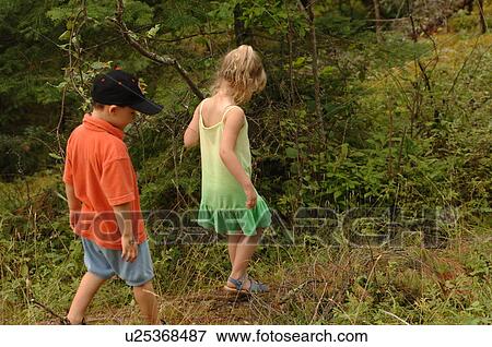 Two small children walking through forest View Large Photo Image Stock Photo - Two small children walking through forest. Fotosearch