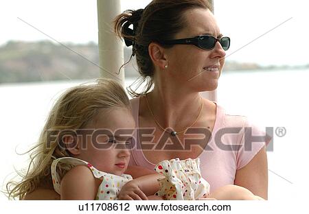 A young woman holding her daughter (6-8) View Large Photo Image Stock Image - A young woman holding her daughter (6-8). Fotosearch