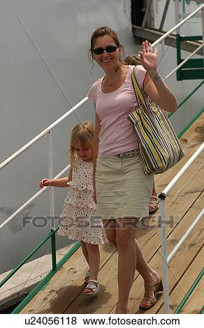Stock Photo - A young woman walking with her daughter. Fotosearch