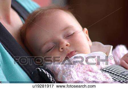 Baby sleeping in mother's arms View Large Photo Image Stock Photo - Baby sleeping in mother's arms. Fotosearch