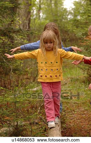 Stock Image - Children balancing on a log. Fotosearch
