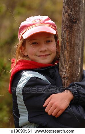 Stock Image - Girl with arms around a pole. Fotosearch
