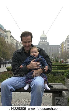 Stock Photography - Portrait of young man holding baby. Fotosearch