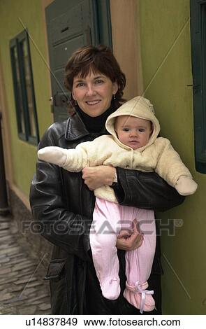 Stock Photo - Portrait of young woman holding a baby. Fotosearch
