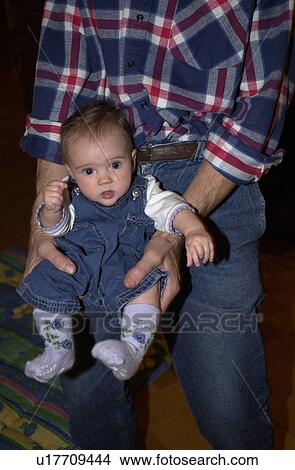 Picture - Young man holding a baby. Fotosearch