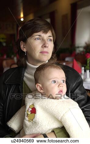 Young woman holding a baby View Large Photo Image Stock Photo - Young woman holding a baby. Fotosearch
