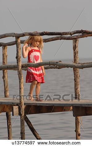 4 year old girl walking on wooden pier View Large Photo Image Stock Photo - 4 year old girl walking on wooden pier. Fotosearch