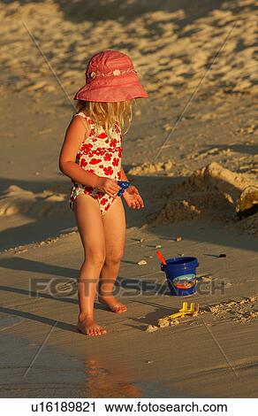 A young girl (6-8) on a beach View Large Photo Image Stock Image - A young girl (6-8) on a beach. Fotosearch