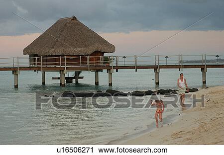 A young girl (6-8) playing with her mother on a beach, Moorea, Tahiti, French Polynesia, South Pacific View Large Photo Image Stock Image - A young girl (6-8) playing with her mother on a beach, Moorea, Tahiti, French Polynesia, South Pacific. Fotosearch