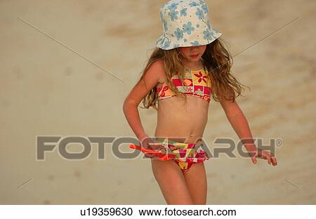 Close-up of a young girl (6-8), on a beach View Large Photo Image Stock Image - Close-up of a young girl (6-8), on a beach. Fotosearch