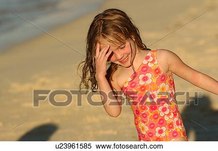 Close-up of a young girl (6-8) playing on a beach View Large Photo Image Stock Photography - Close-up of a young girl (6-8) playing on a beach. Fotosearch