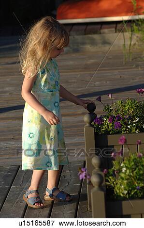 Girl in sundress standing on wooden deck View Large Photo Image Stock Photo - Girl in sundress standing on wooden deck. Fotosearch