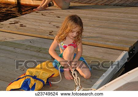 Picture - Girl tying a rope. Fotosearch