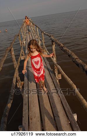 Mother and daughter walking on wooden pier View Large Photo Image Stock Photo - Mother and daughter walking on wooden pier. Fotosearch