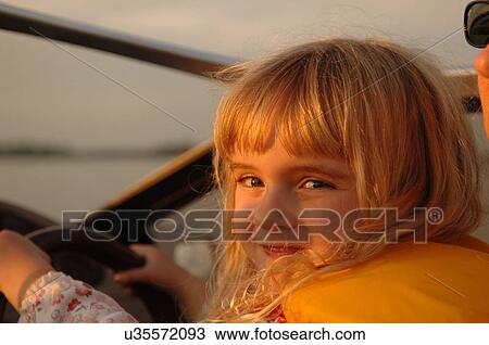Small child holding onto boat steering wheel View Large Photo Image Stock Image - Small child holding onto boat steering wheel. Fotosearch