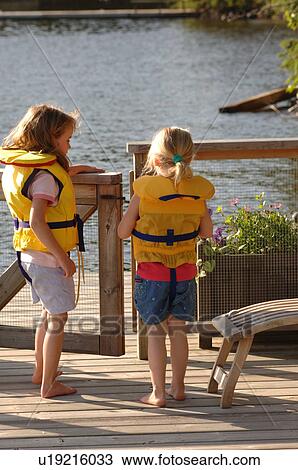 Two girls in lifejackets on a deck View Large Photo Image Stock Image - Two girls in lifejackets on a deck. Fotosearch