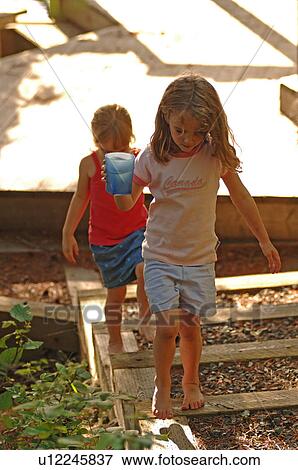 Two girls standing on wooden boards View Large Photo Image Stock Photo - Two girls standing on wooden boards. Fotosearch