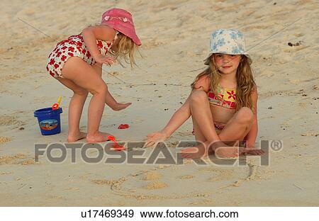 Stock Photo - Two young girl's (6-8) playing on a beach. Fotosearch