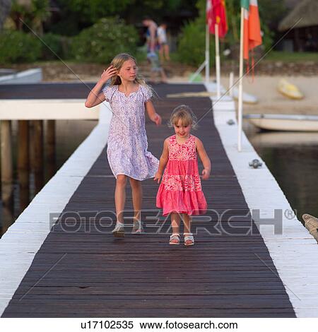 Stock Photography - Two Young Girls Walking on Dock. Fotosearch