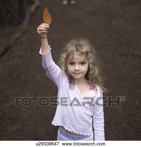 Young Girl Holding up a Leaf View Large Photo Image Stock Photo - Young Girl Holding up a Leaf. Fotosearch