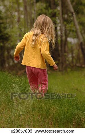 Blonde child walking through field of grass View Large Photo Image Stock Image - Blonde child walking through field of grass. Fotosearch
