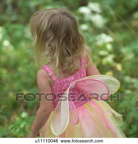 Rear view of a young girl in a fairy costume standing in a garden View Large Photo Image Stock Photo - Rear view of a young girl in a fairy costume standing in a garden. Fotosearch