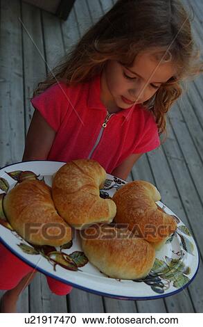 Young girl holding a plate of croissants View Large Photo Image Stock Image - Young girl holding a plate of croissants. Fotosearch
