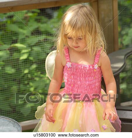 Stock Image - Young girl in a fairy costume standing outdoors. Fotosearch