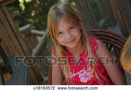 Young girl sitting on a chair looking at camera View Large Photo Image Stock Image - Young girl sitting on a chair looking at camera. Fotosearch