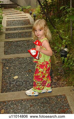 Young girl standing holding a bag View Large Photo Image Stock Photograph - Young girl standing holding a bag. Fotosearch