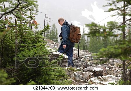 Stock Photo - A man climbing a hilly trail. Fotosearch