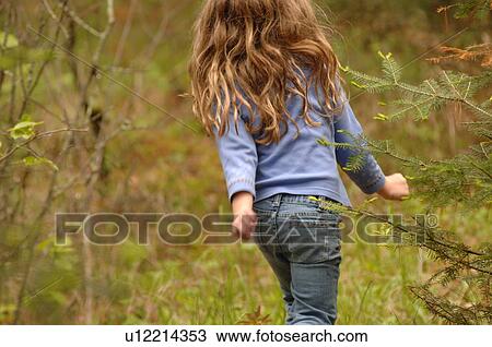 Stock Image - Back of small child in forest. Fotosearch