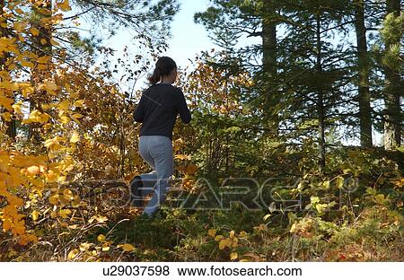 Girl running through forest View Large Photo Image Stock Photo - Girl running through forest. Fotosearch