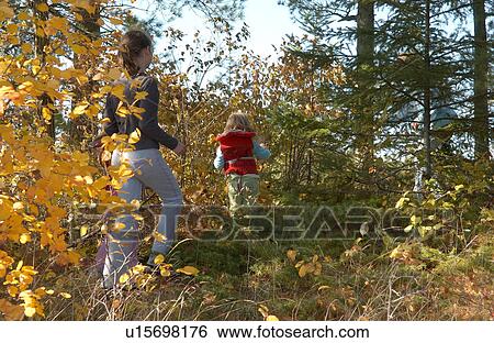 Stock Photograph - Girls walking amongst foliage. Fotosearch