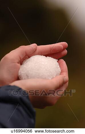 Stock Photograph - Hand holding snow ball. Fotosearch