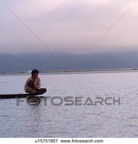 Stock Photo - Intha fisherman in his flat-bottomed boat. Fotosearch