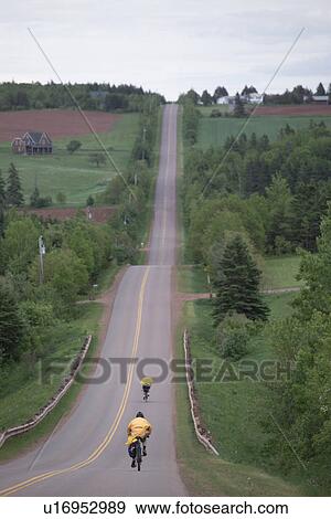 Two cyclists traveling down a road View Large Photo Image Stock Photo - Two cyclists traveling down a road. Fotosearch