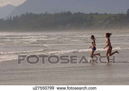 Two women running into ocean View Large Photo Image Stock Photo - Two women running into ocean. Fotosearch
