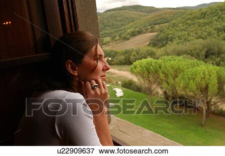 Stock Photo - Woman Looking Out Window at View. Fotosearch